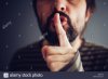 man-saying-hush-or-be-quiet-with-finger-on-lips-close-up-with-selective-M62DY9.jpg